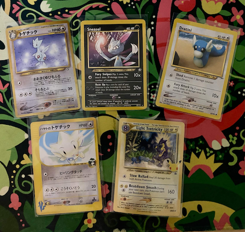 a display of 5 pokemon cards. togetic, sneasel, dratini,
                                                                              falkner's togetic, and light toxtricity are depicted
                                                                              on them.